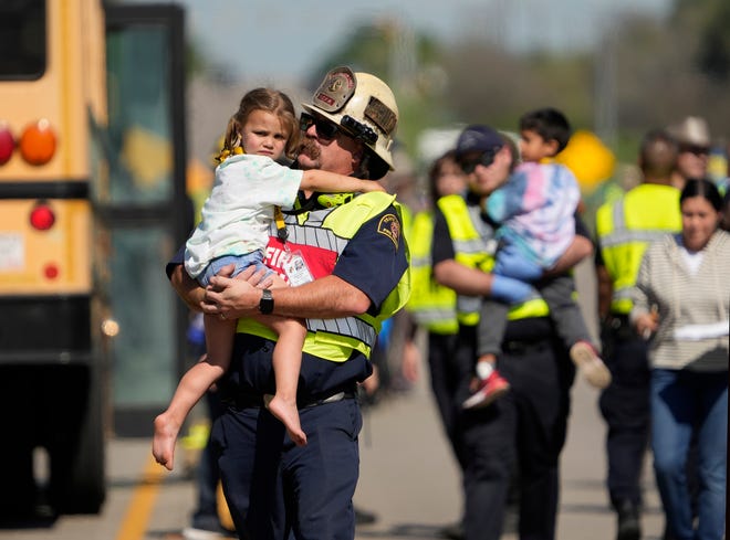 Travis County Fire Rescue Battalion Chief Jason Pack comforts a girl from a fatal school bus crash on SH 21 near Caldwell Road Friday March 22, 2024.

Editor's note: The Austin American-Statesman is publishing photos of first responders and children following the school bus crash after careful consideration to document the breaking news and public safety nature of the incident.