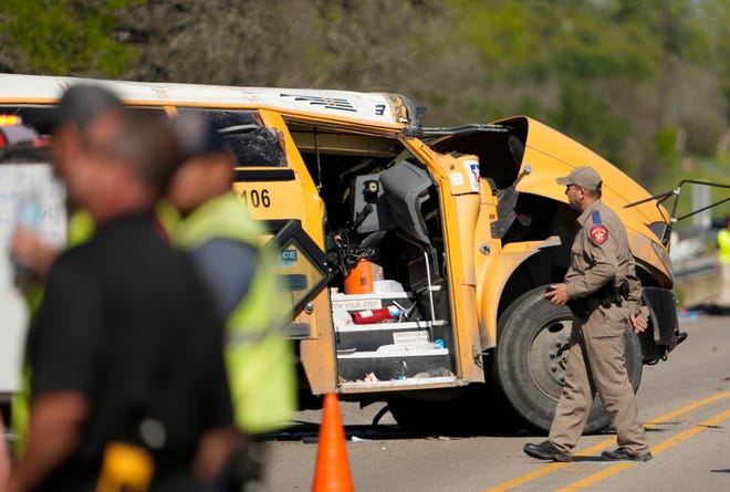 A DPS trooper looks at a school bus crash on SH 21 near Caldwell Road Friday March 22, 2024.