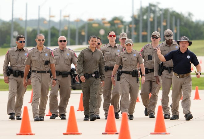 Department of Public Safety troopers walk the track before competing in the driving skills contest at the 12th Annual Top Trooper Competition at the DPS Tactical Training Center in Florence Tuesday April 23, 2024. The weeklong event has 120 troopers competing in physical fitness, driving and firearms skills, and job knowledge. The male and female winners will earn the Javier Arana, Jr. Top Trooper Award, named after fallen Trooper Javier Arana, Jr., who participated in the inaugural competition, and get a new patrol vehicle.